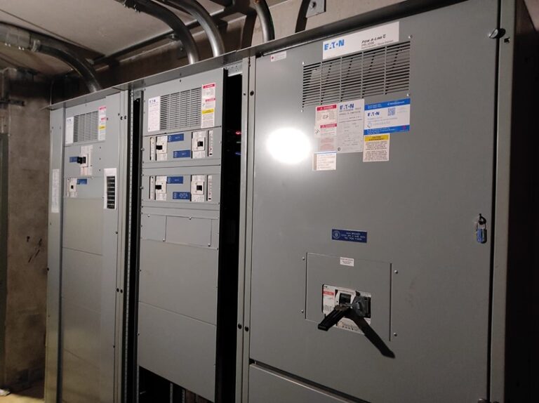 Commercial facility electrical room with labeled electrical distribution panels.