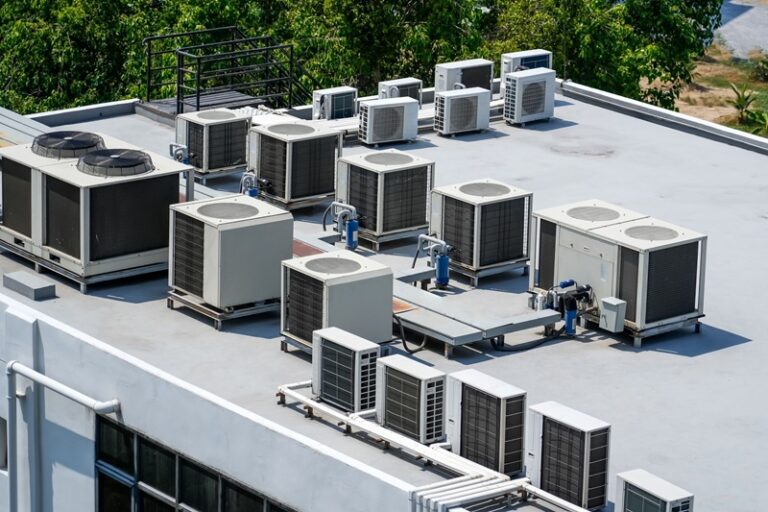 Wireless temperature sensor mounted near a commercial rooftop HVAC unit