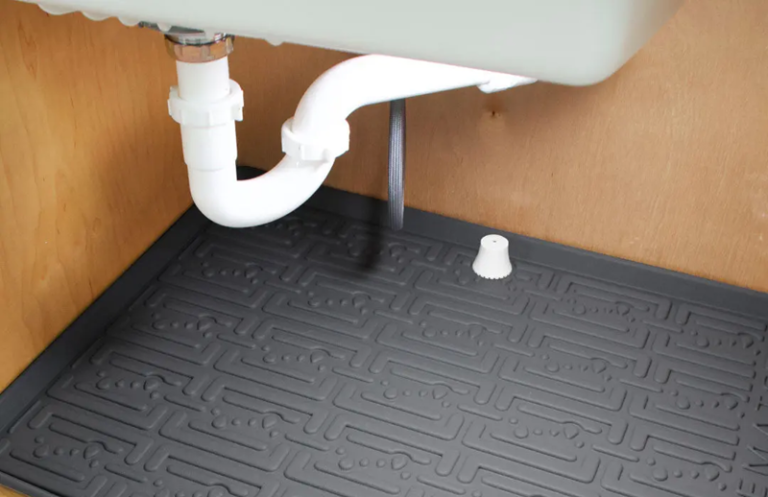 Wireless water leak sensor placed on the floor near a commercial water heater