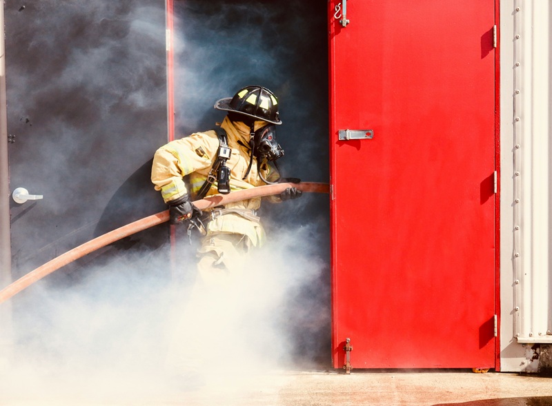 Commercial fire door with closer hardware and an inspection tag, representing a fire door compliance inspection.