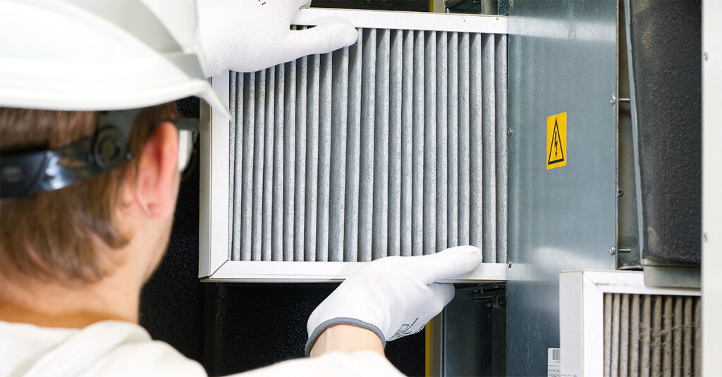 Facility technician performing a scheduled preventative maintenance check on HVAC equipment before any failure has occurred.