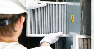 Facility technician performing a scheduled preventative maintenance check on HVAC equipment before any failure has occurred.