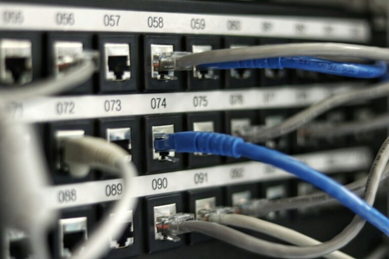 Technician terminating Cat6A structured cabling at a patch panel during a commercial cabling installation.
