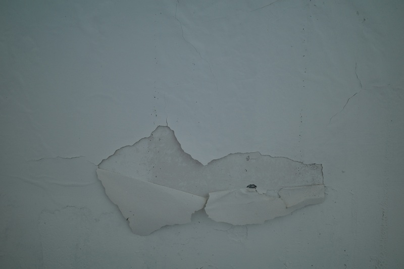 Water-stained ceiling tile above damaged drywall, showing a connected interior water intrusion issue.